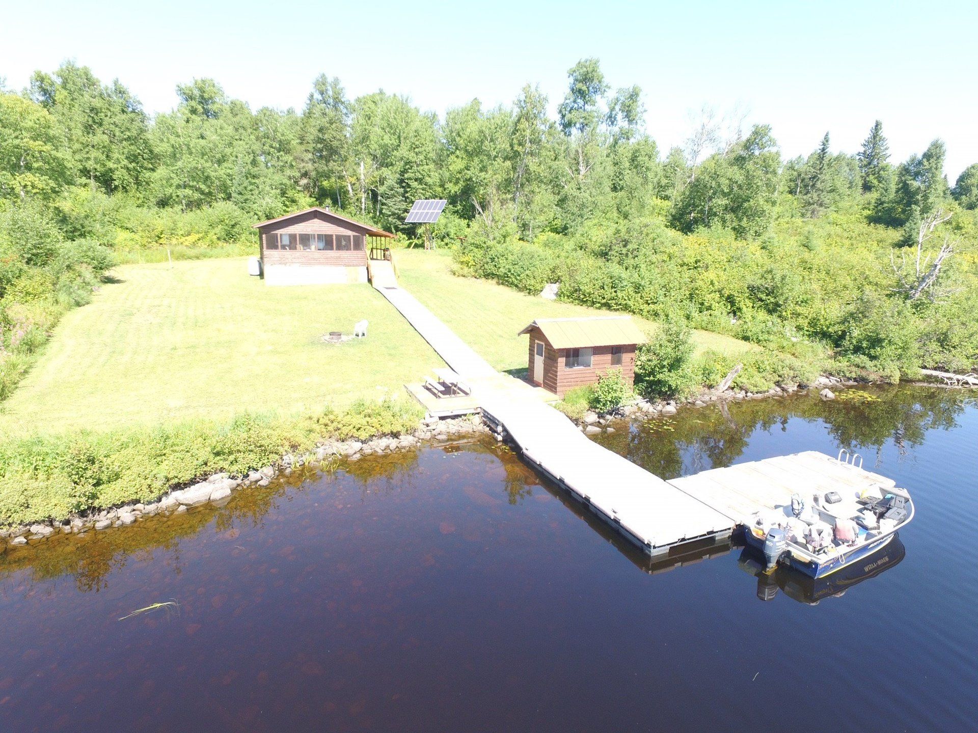 An aerial view of a dock and a house on a lake