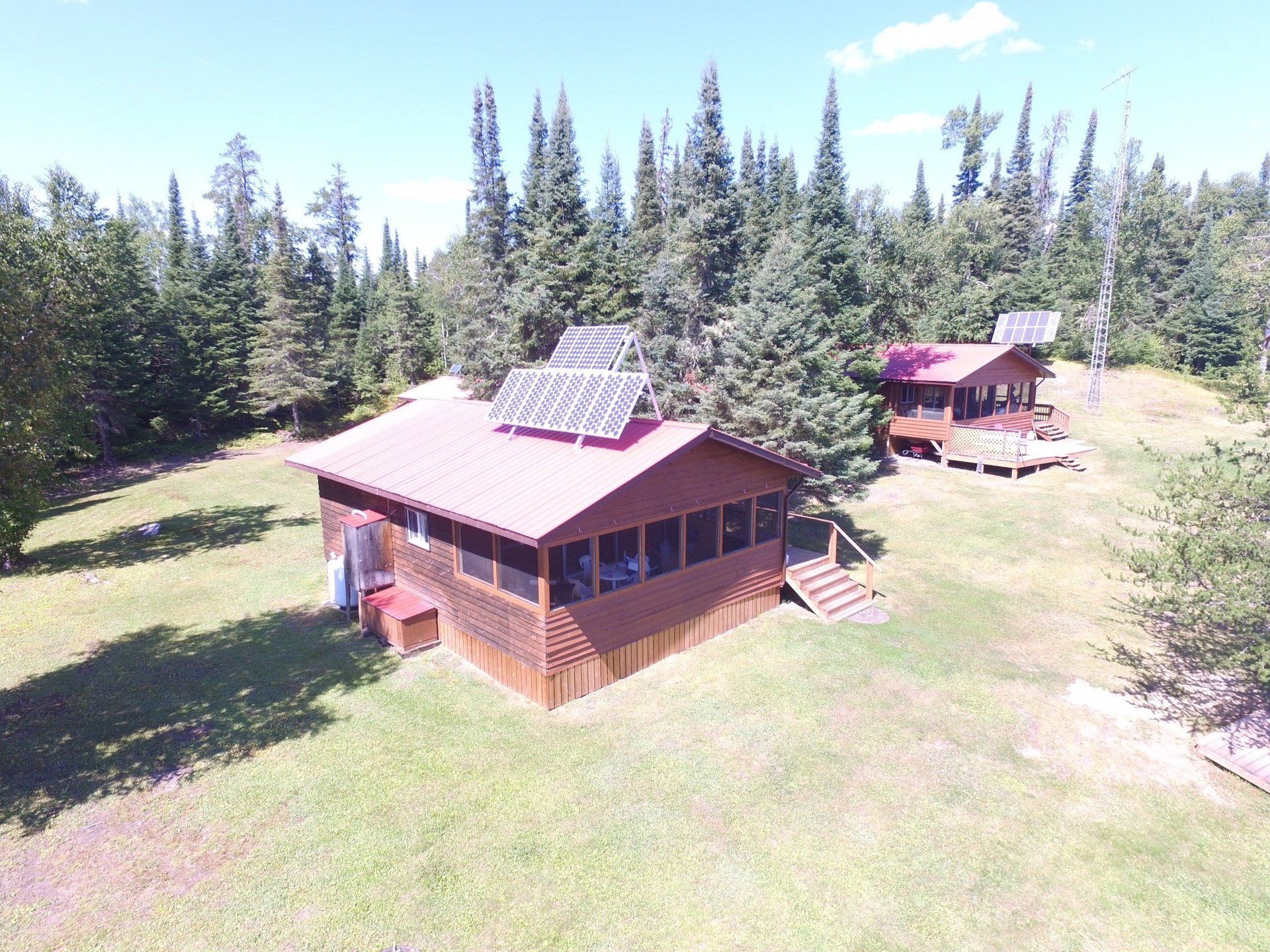 An aerial view of a cabin in the middle of a forest