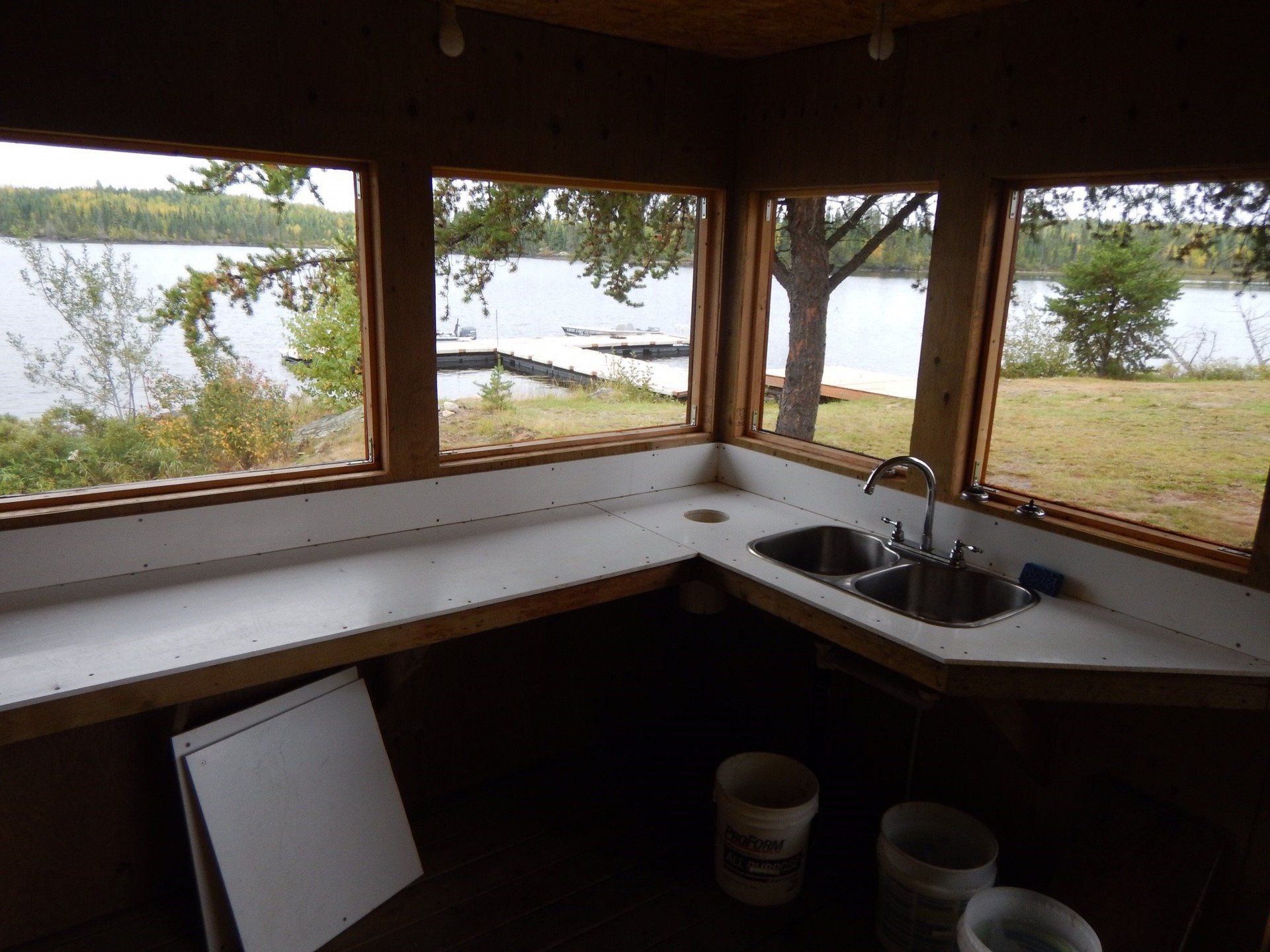 A kitchen with two sinks and a view of a lake