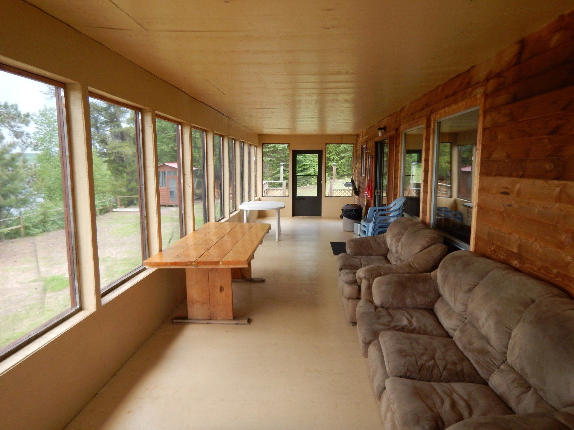A screened in porch with a table and chairs