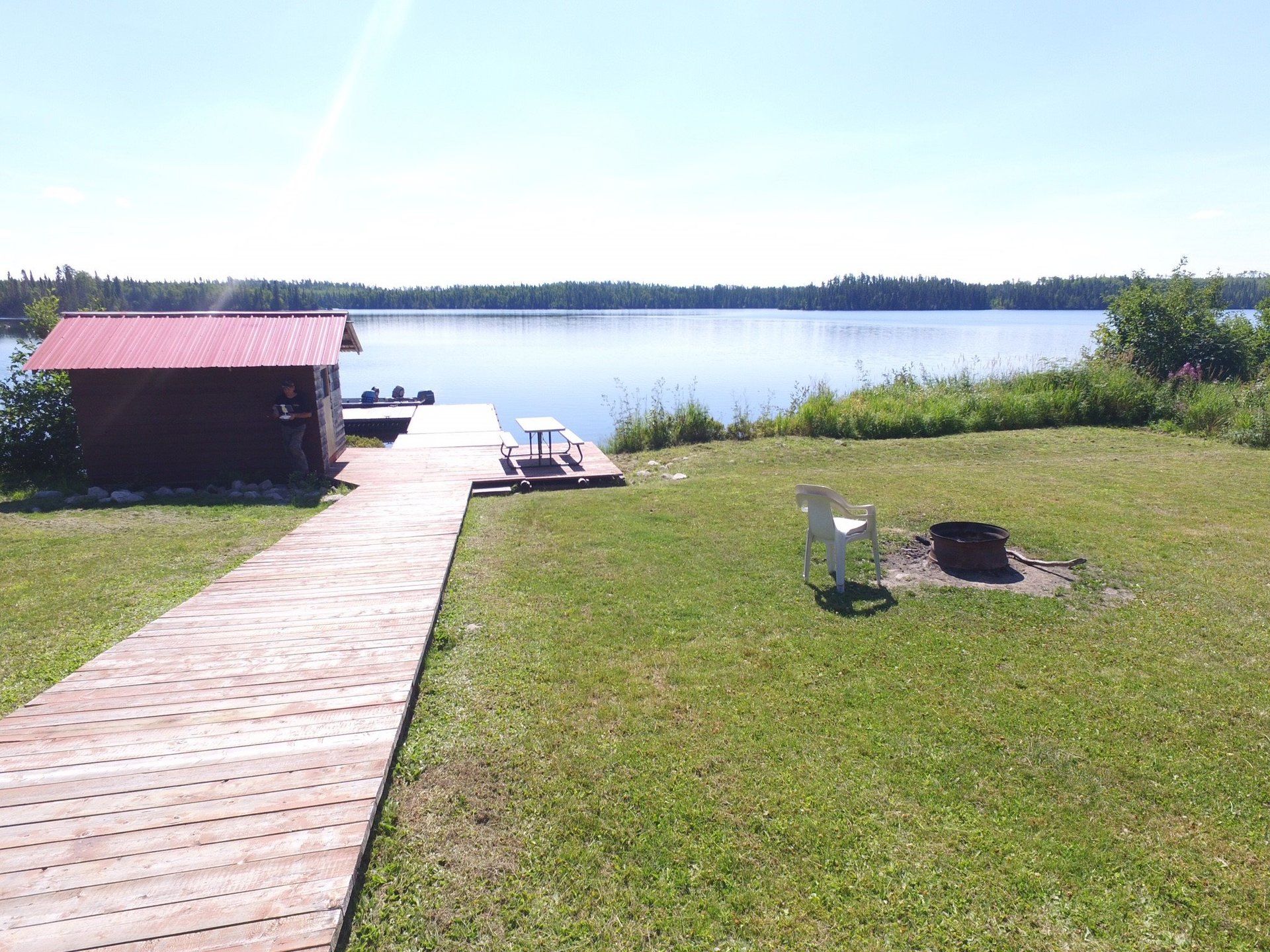 A wooden walkway leading to a dock overlooking a lake