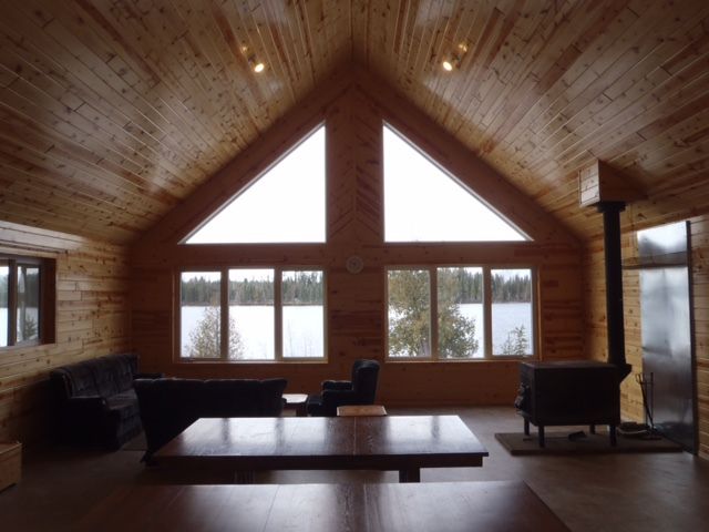 A living room with a vaulted ceiling and lots of windows