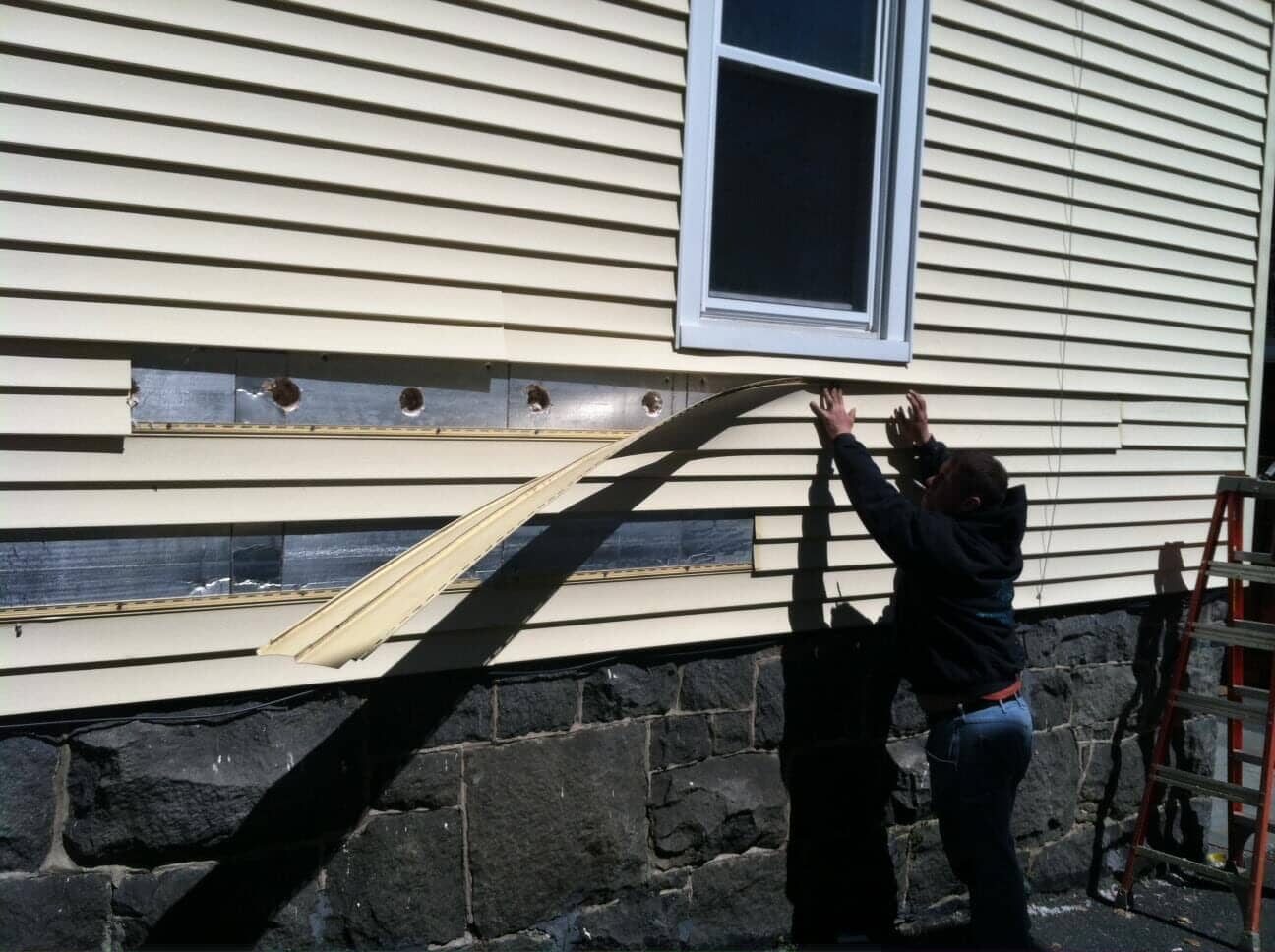 Man fixing outdoor insulation — Home Insulation in Whitehouse Station, NJ