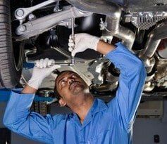Mechanic under a Car - Auto Glass Replacements Mechanic under a Car - Auto Glass Replacements