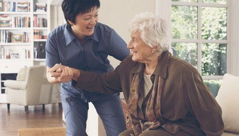 A carer lifting an elderly person