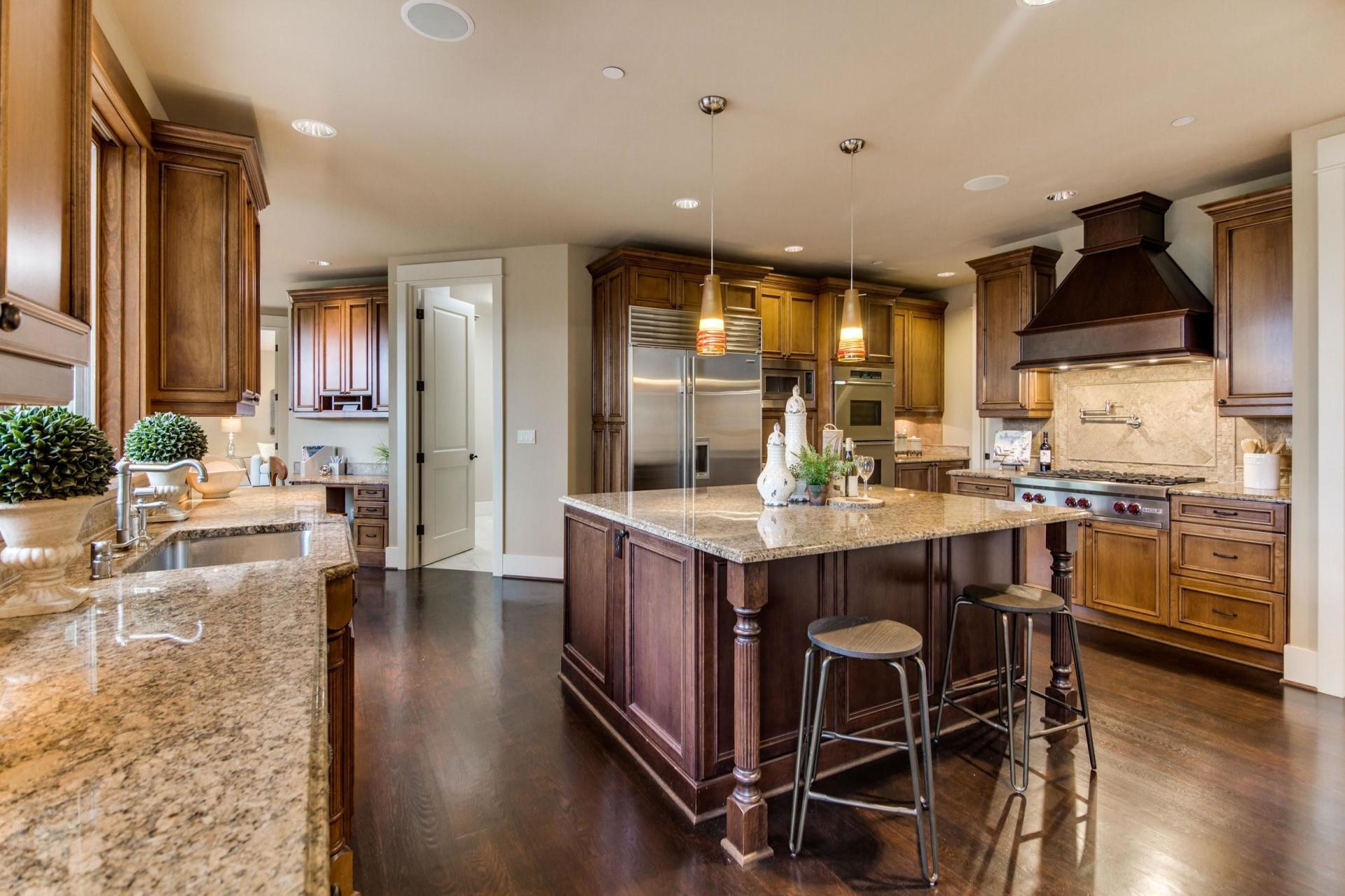 Spacious kitchen with wood cabinets, island, and stainless steel appliances.