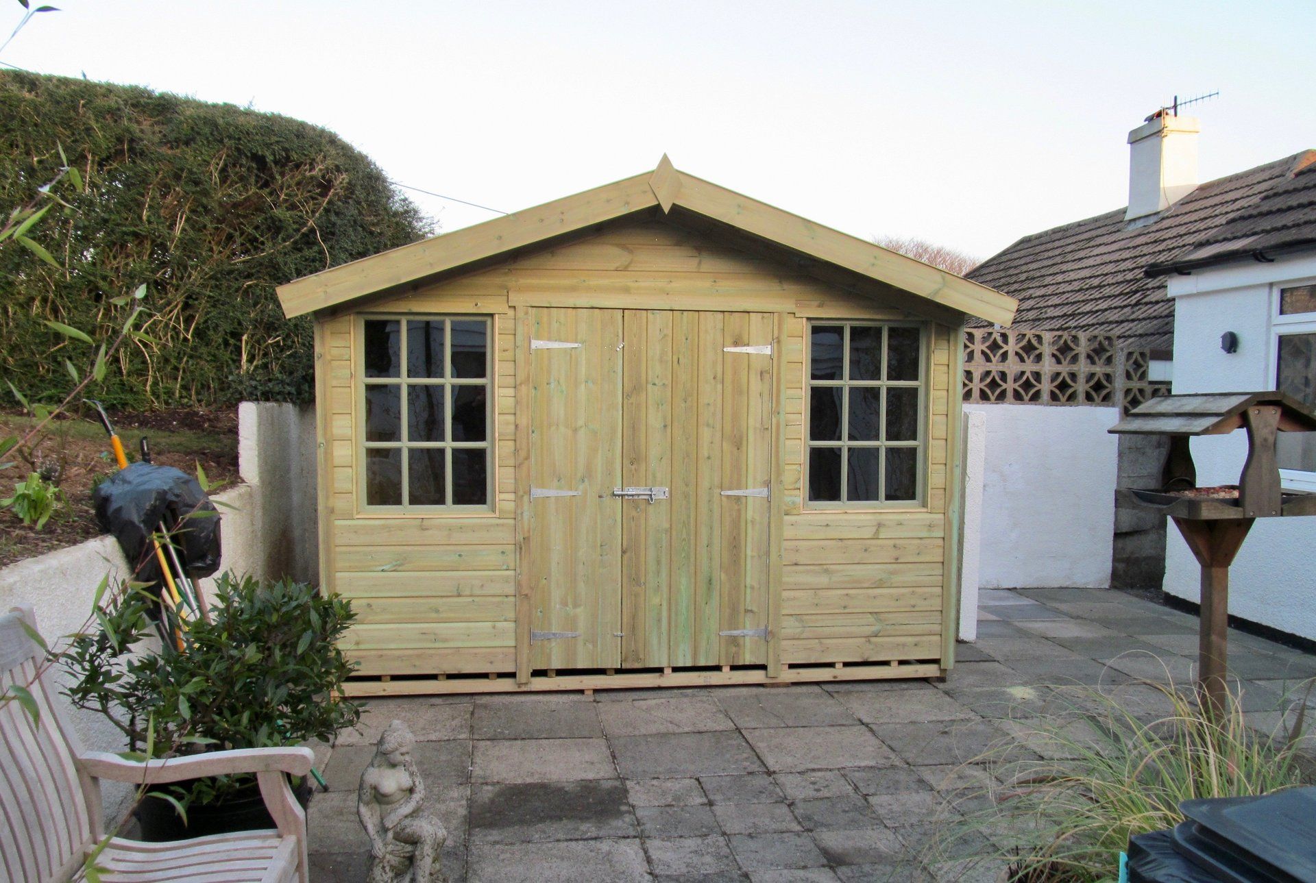 Exeter Cabin Shed with a summerhouse feel door in the middle and a painted window on each side of the door