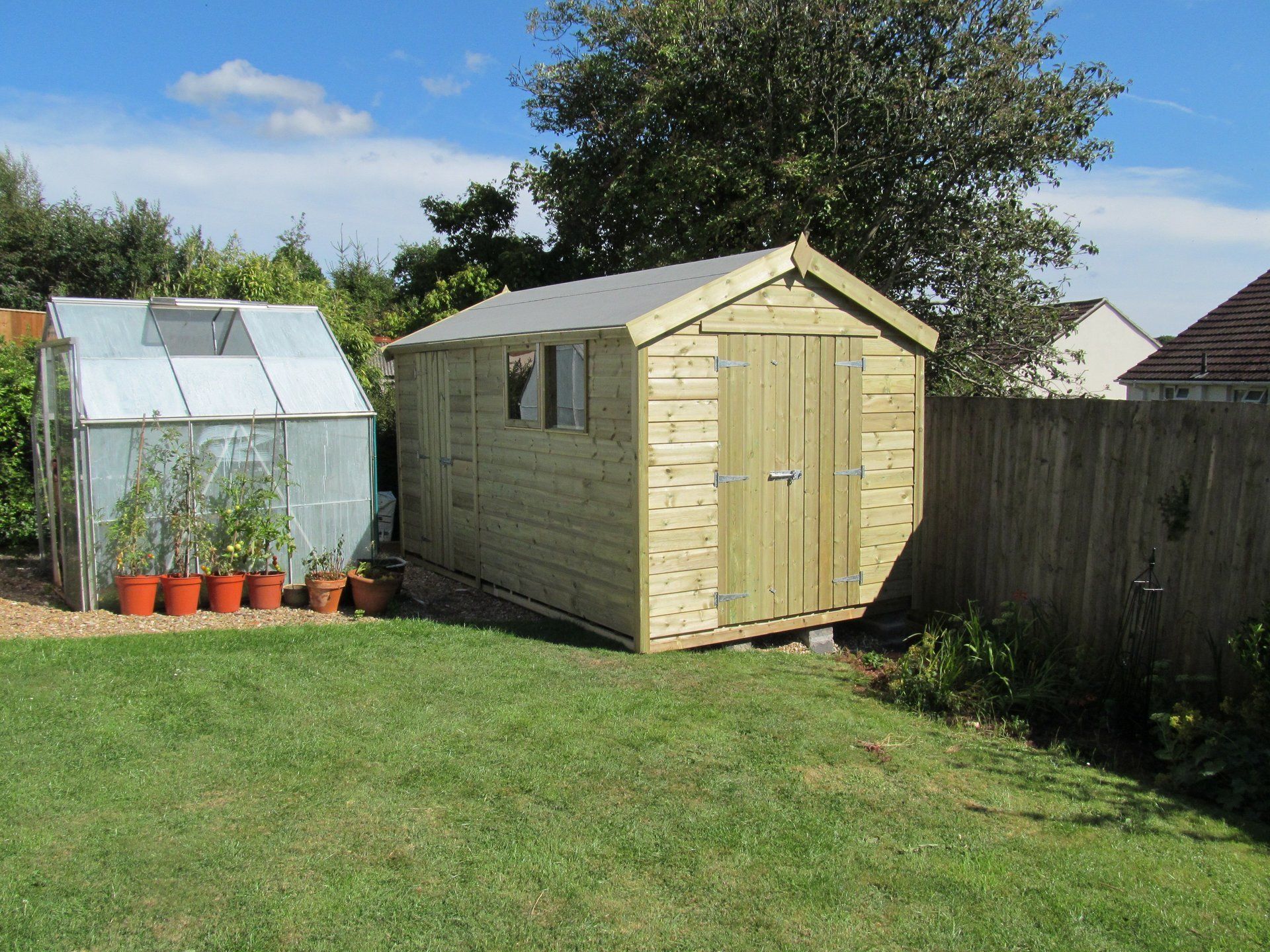 Traditional Workshop Shed next to greenhouse with door to the front and triple windows to the side