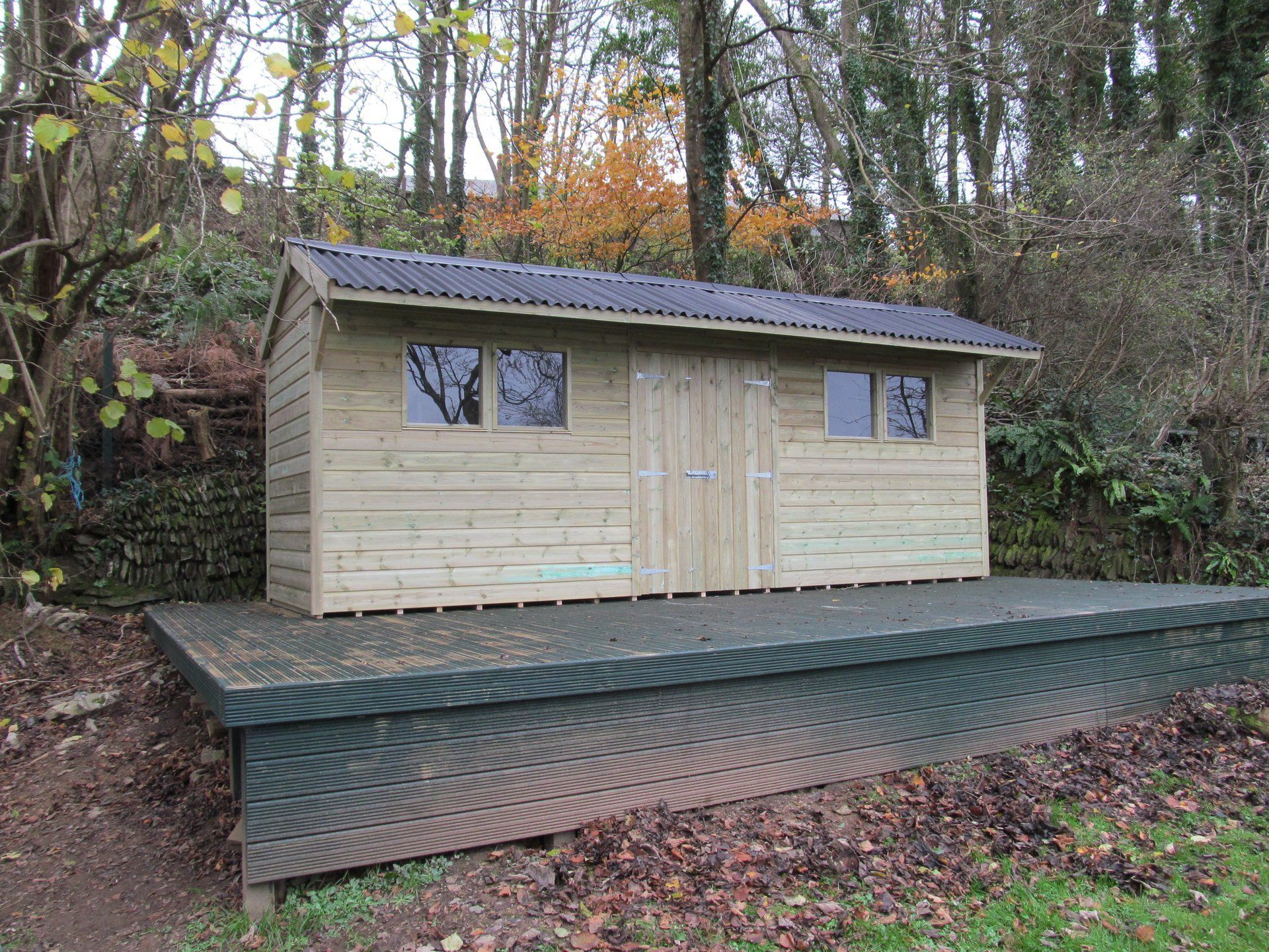 Extra long cabin shed with lots of storage, angled roof, large doors and two sets of double windows