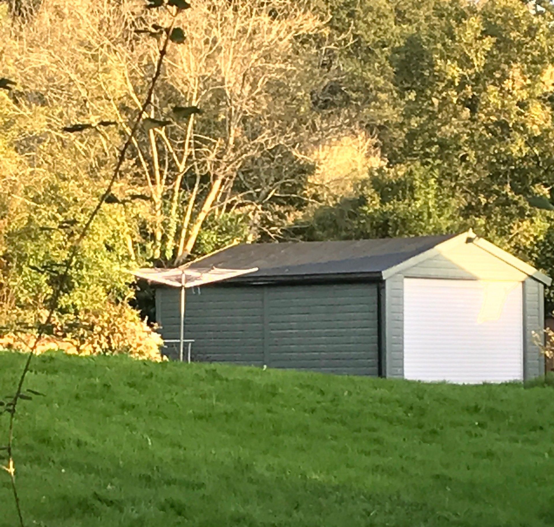 Painted large garage building with white roll up and over door by CP Sheds Devon