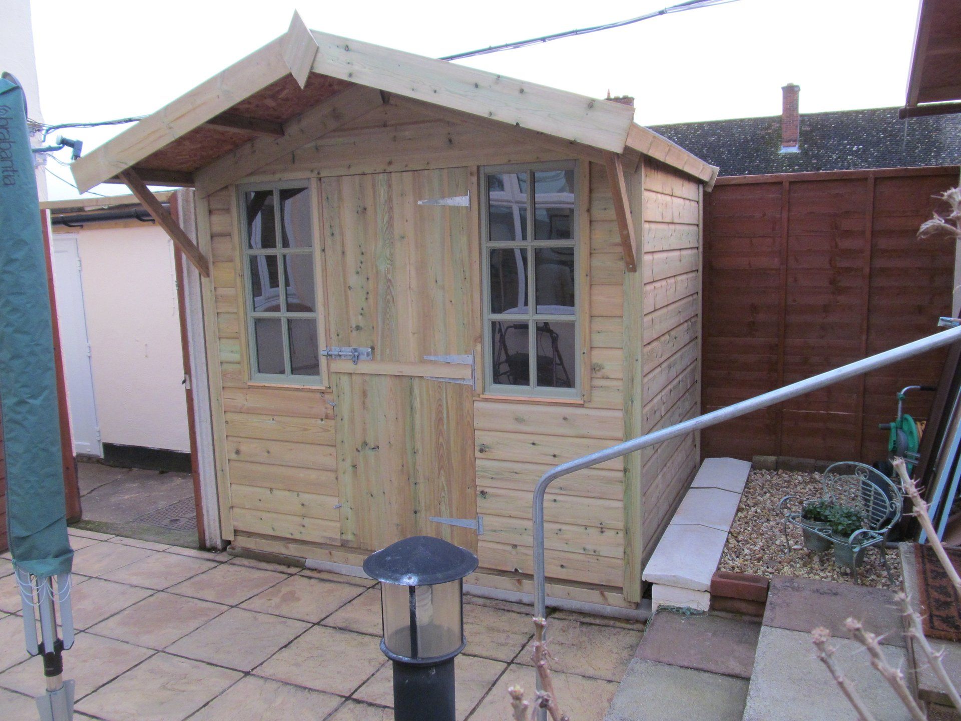 Cabin shed with door to the middle and overhang angled roof