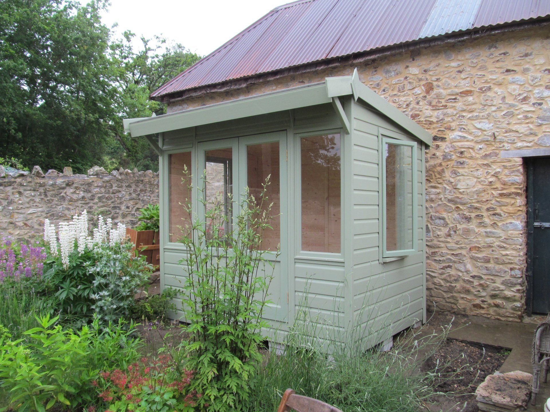 The Ashton Summer House painted in light green by CP Sheds Devon