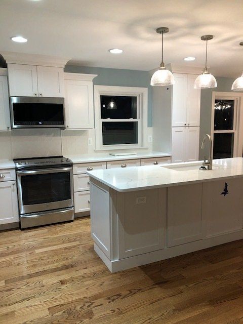A kitchen with white cabinets and stainless steel appliances