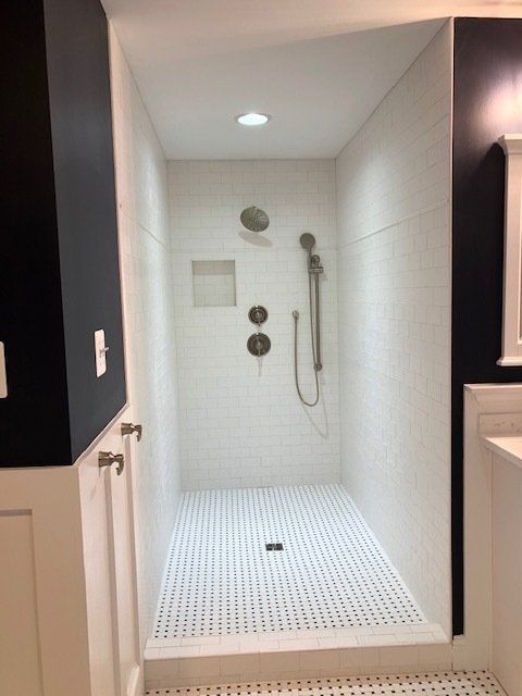 A bathroom with a walk in shower and a sink.