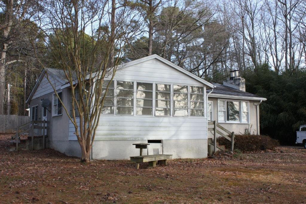 A white house with a picnic table in front of it.