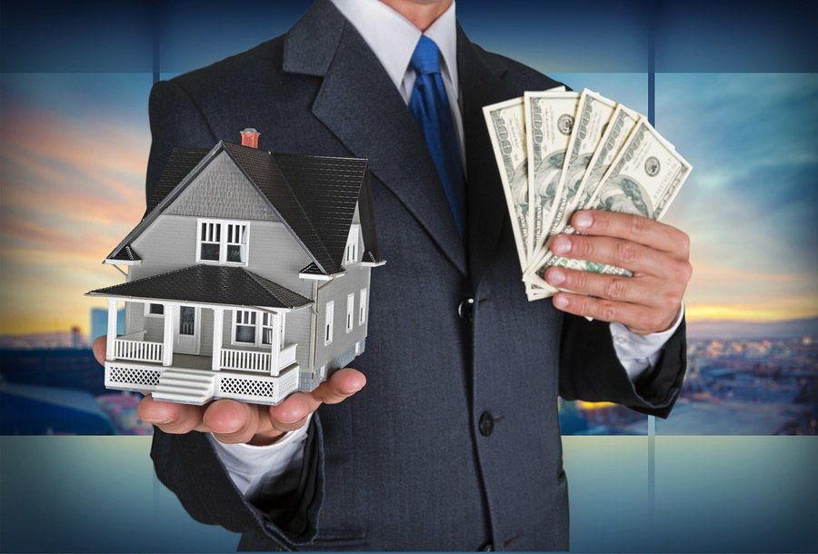 A man in a suit is holding a model house and money