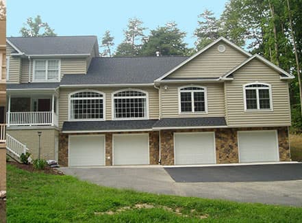 A large house with a lot of windows and garage doors