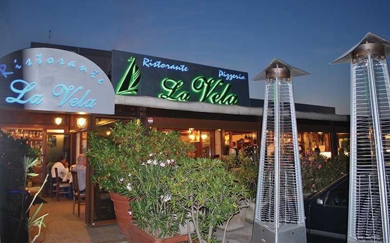 La vetrina del ristorante all'aperto al crepuscolo, con le insegne verdi