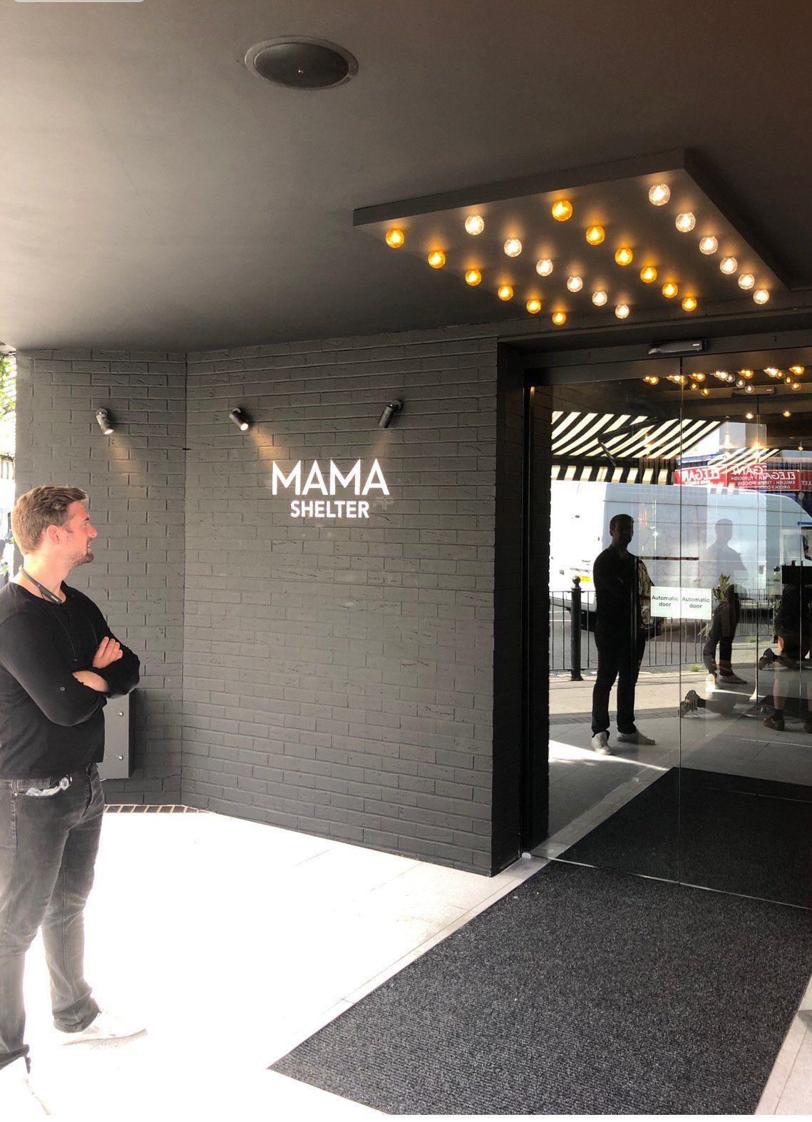 a guy looking at the entrance or his reflection at MAMA Shelter Hotel