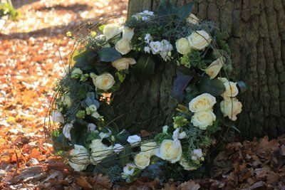 corona di fiori appoggiata su un tronco d'albero