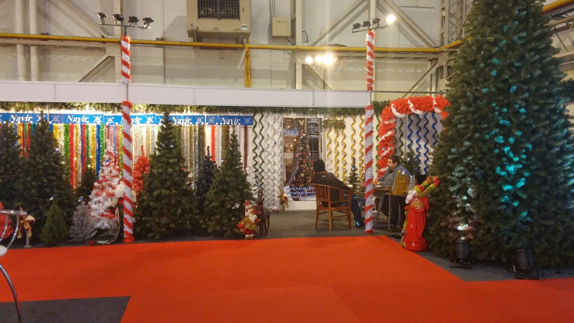 Entrada festiva por la alfombra roja con árboles de Navidad, bastones de caramelo a rayas y coloridas luces navideñas.