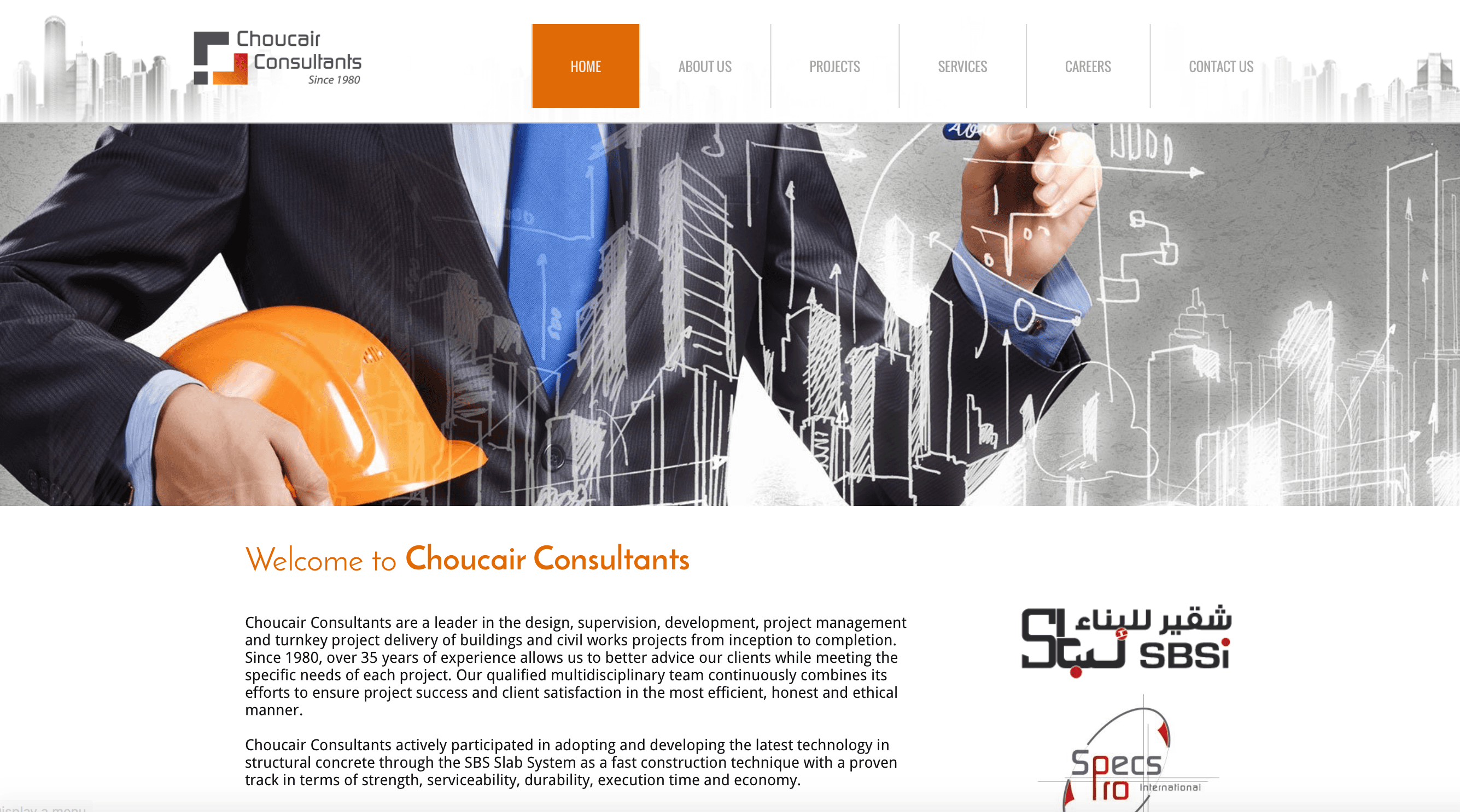A man in a suit is holding an orange hard hat