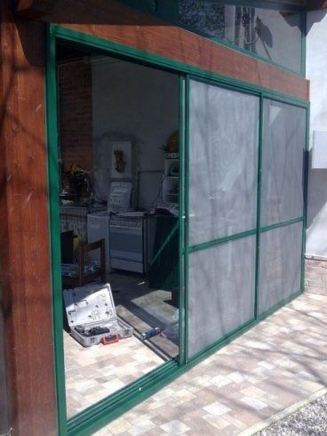 Finestre scorrevoli con zanzariere all'ingresso di un'abitazione