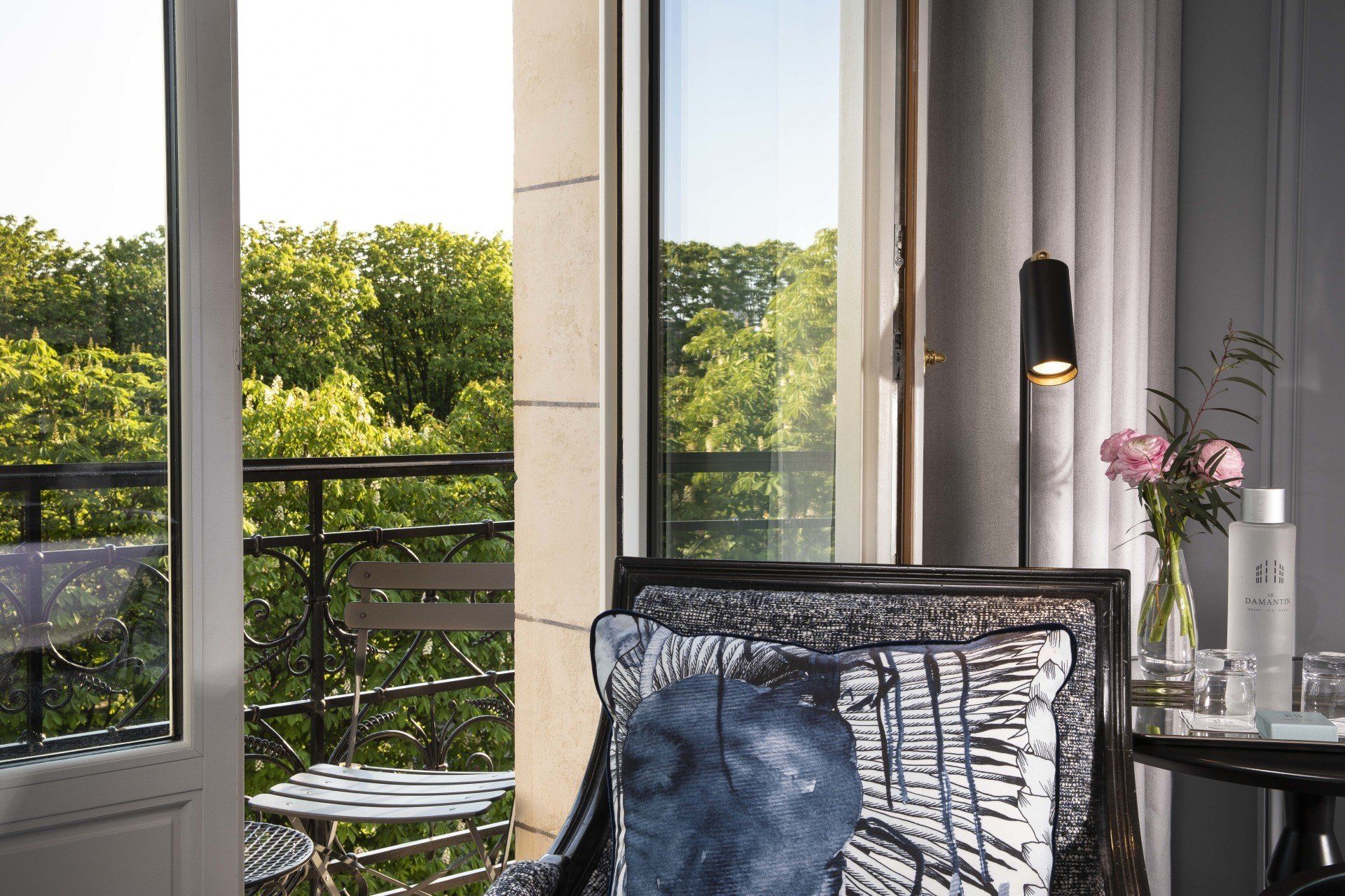 Une chaise avec un coussin bleu est assise devant un balcon.