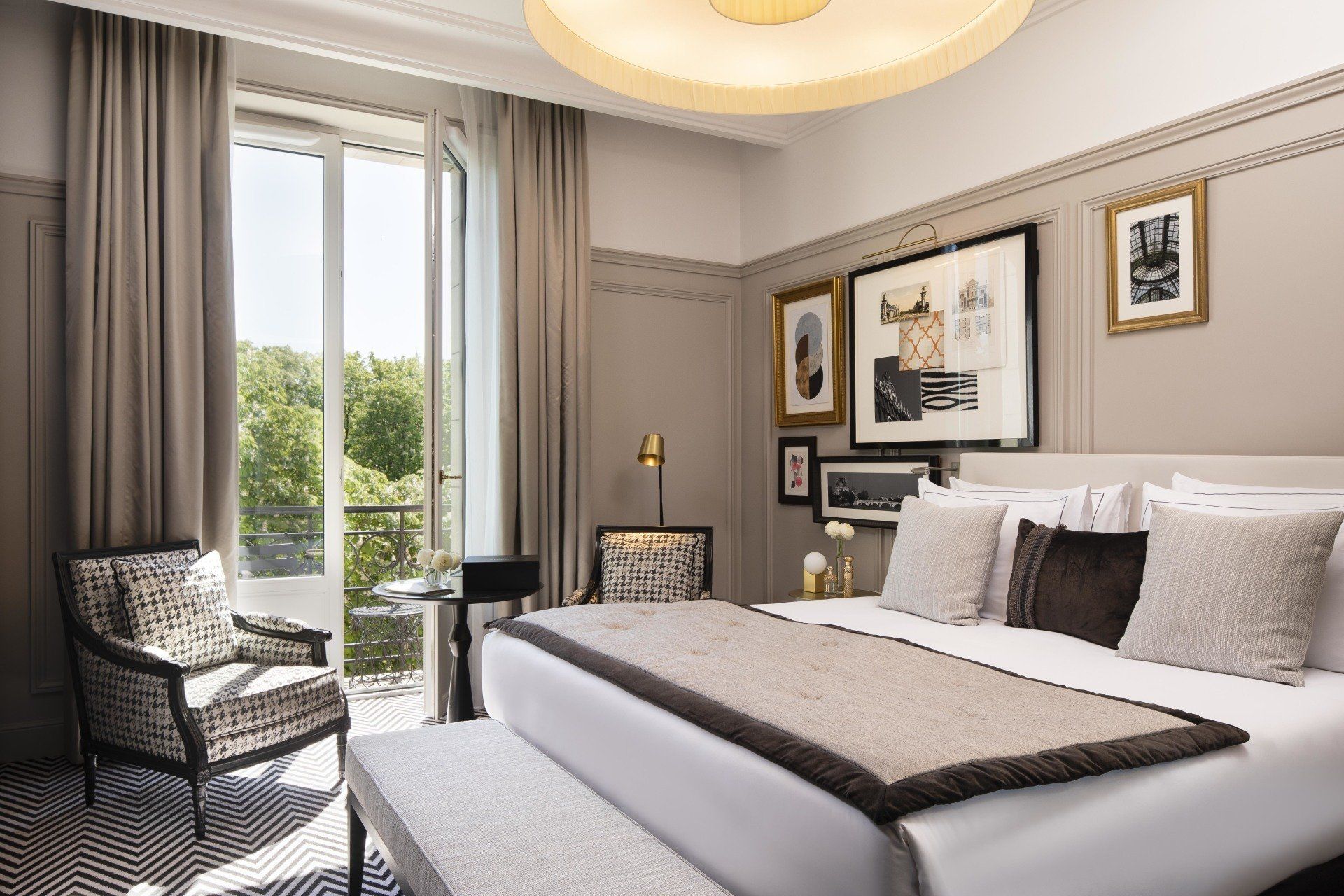 Une chambre avec un grand lit, une chaise, une table et une fenêtre.