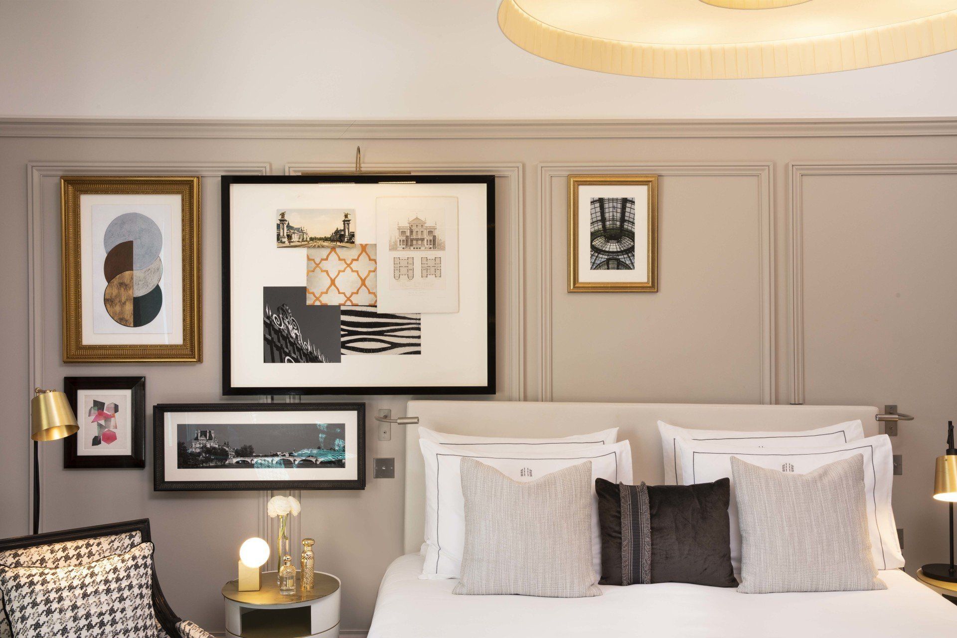 Une chambre avec un lit, une chaise et des tableaux sur le mur.