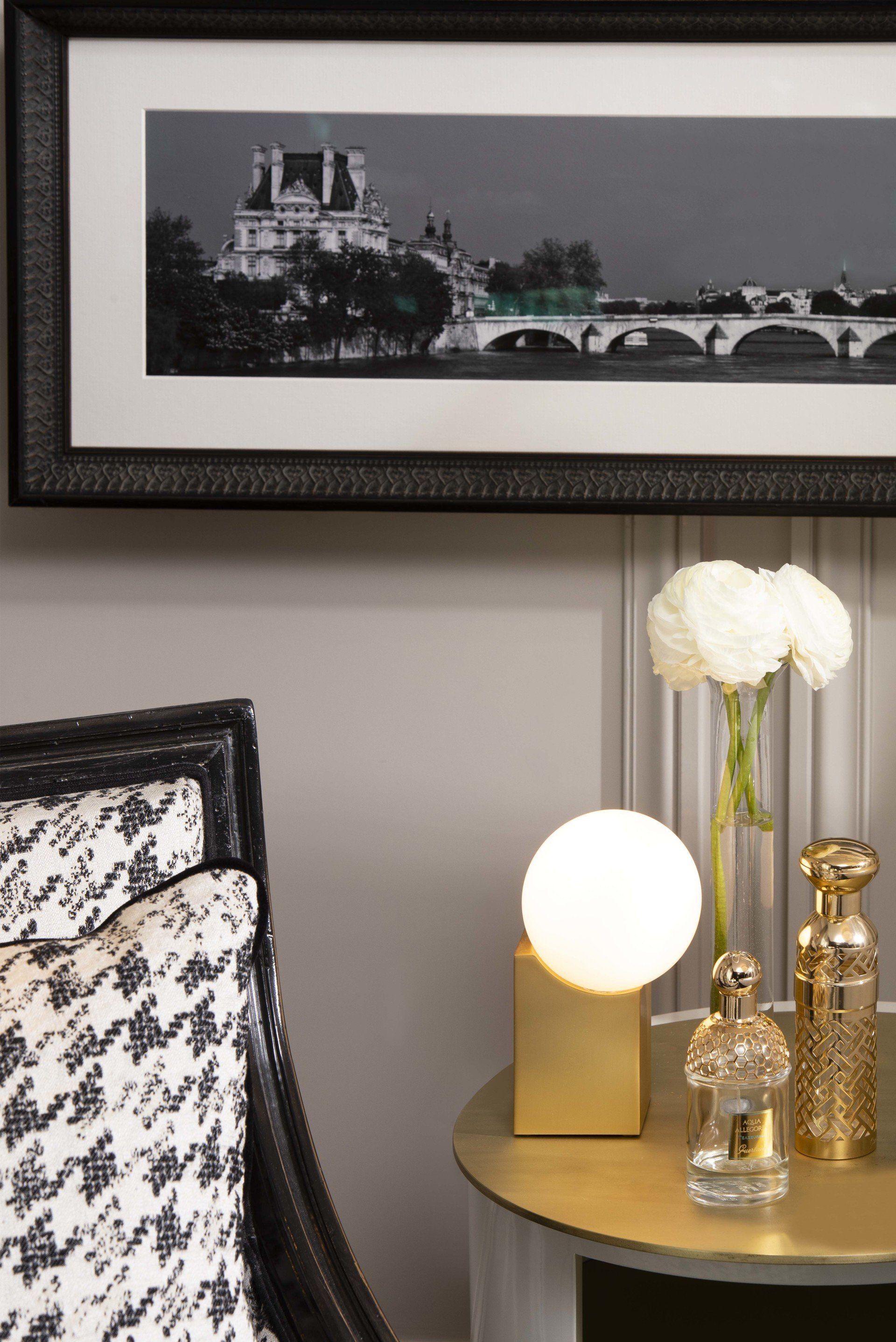 Une table avec une lampe et un tableau sur le mur au-dessus