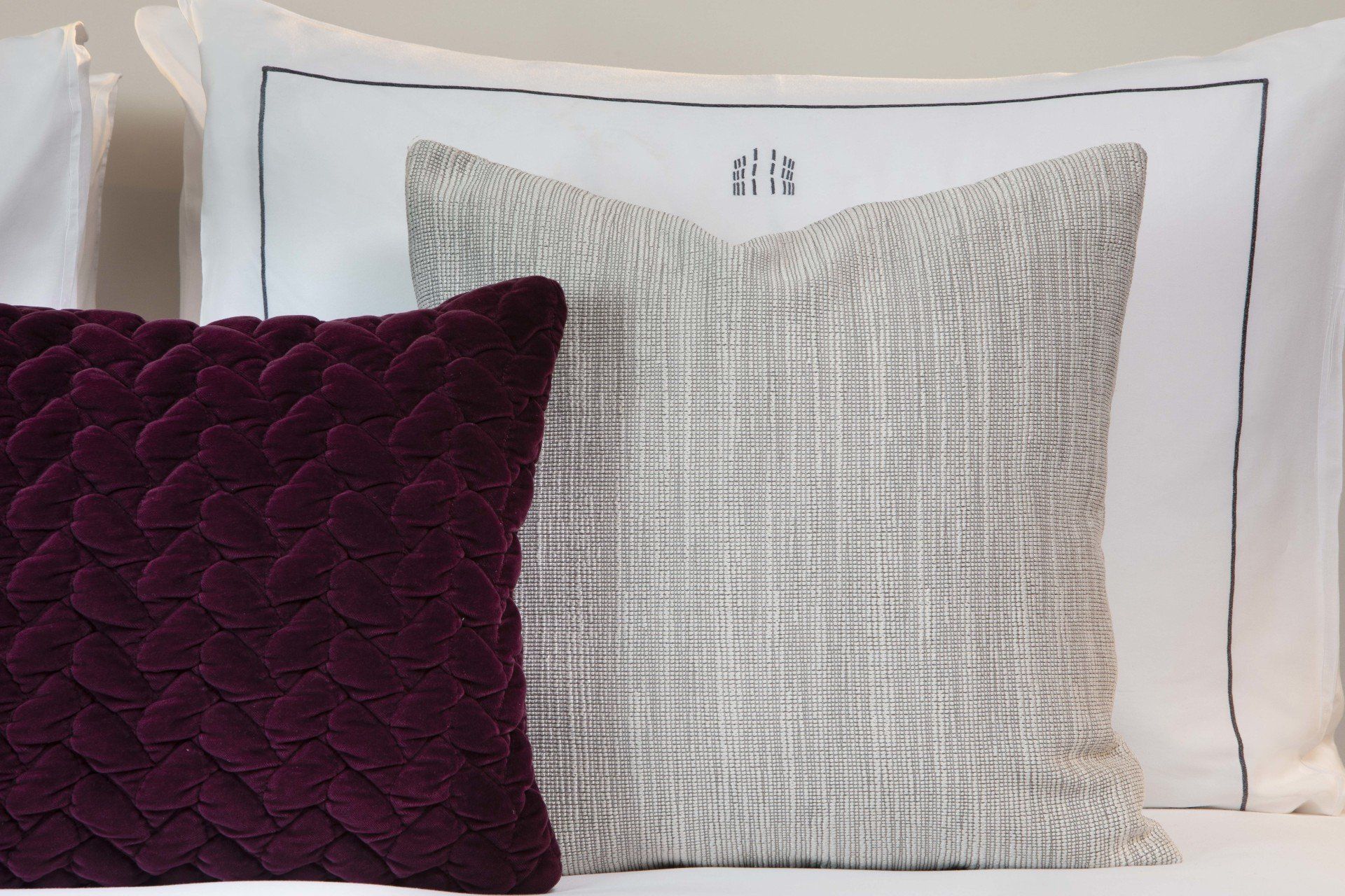 Un lit avec des oreillers violets et blancs dessus