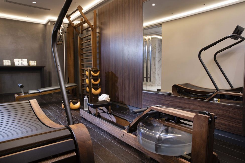 Une salle de sport avec un tapis de course et un rameur