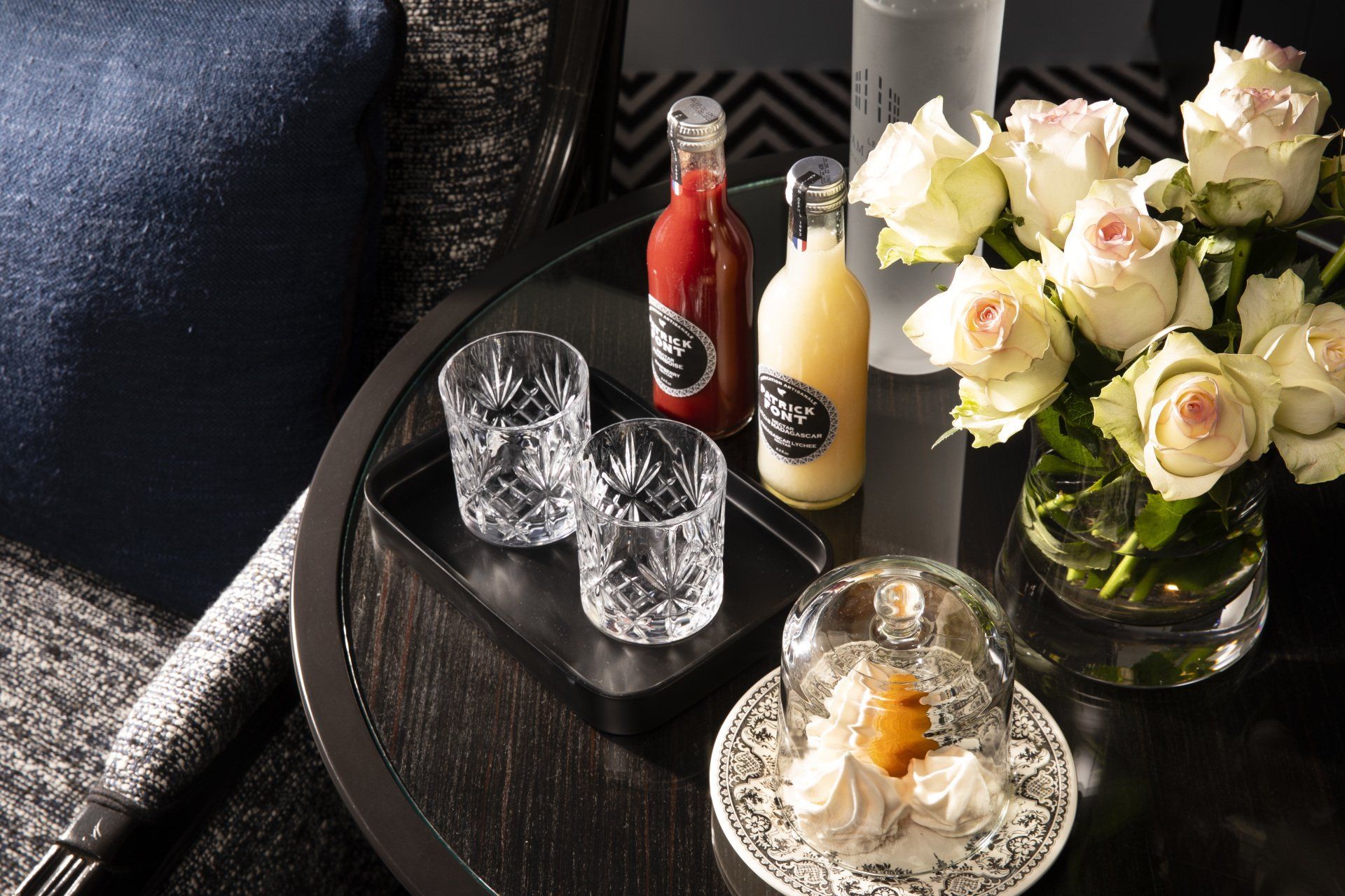Une table avec un plateau de boissons et de fleurs dessus