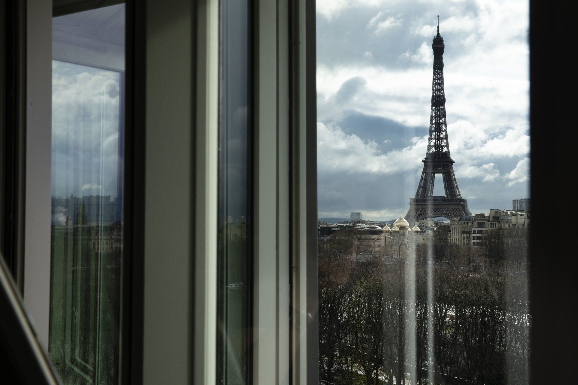 Une vue de la tour Eiffel à travers une fenêtre
