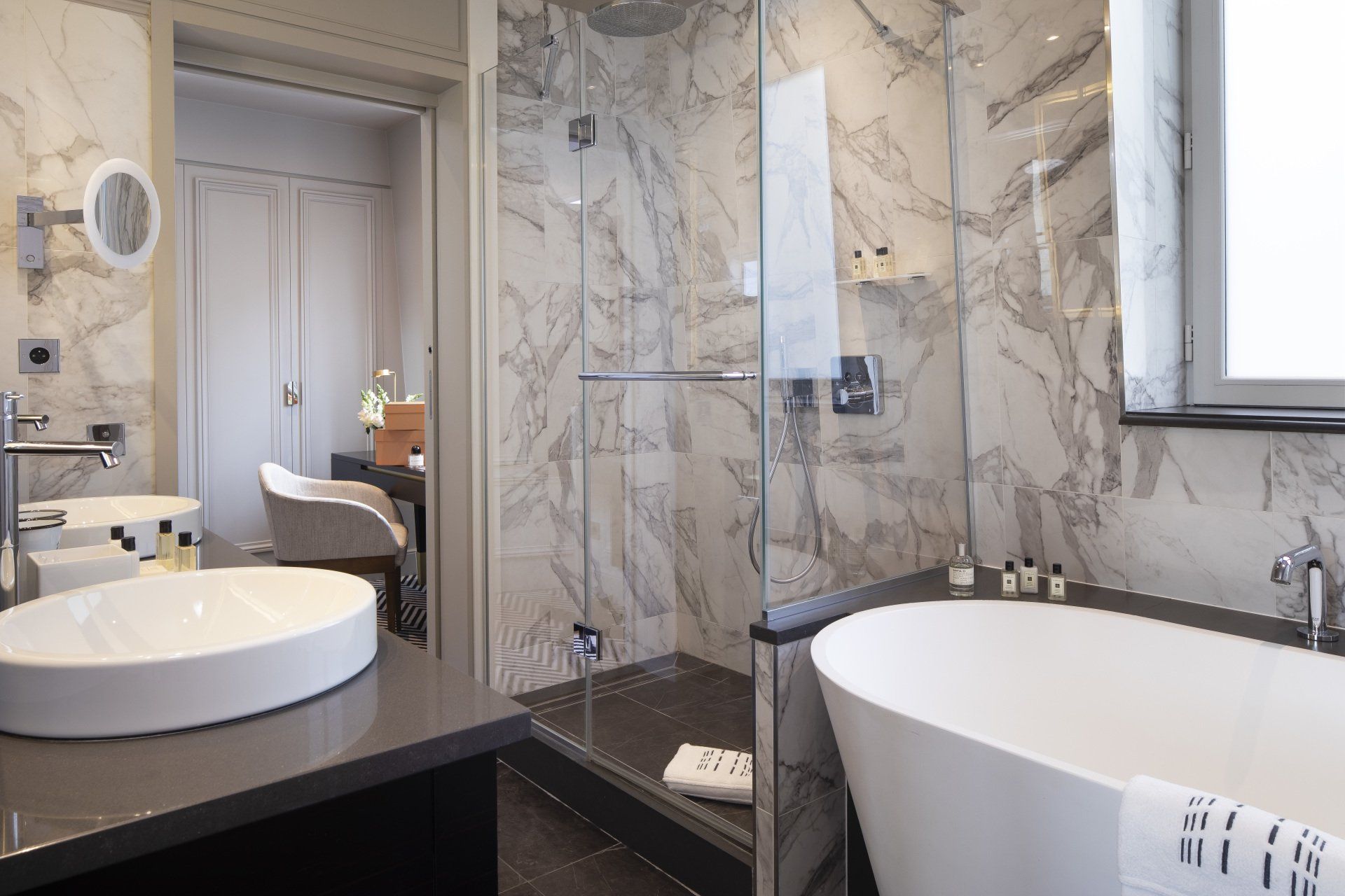 Une salle de bain avec deux lavabos, une baignoire et une douche à l'italienne.
