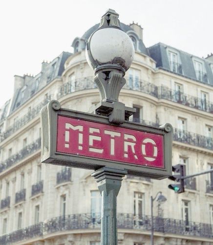 Un panneau rouge indiquant métro devant un bâtiment