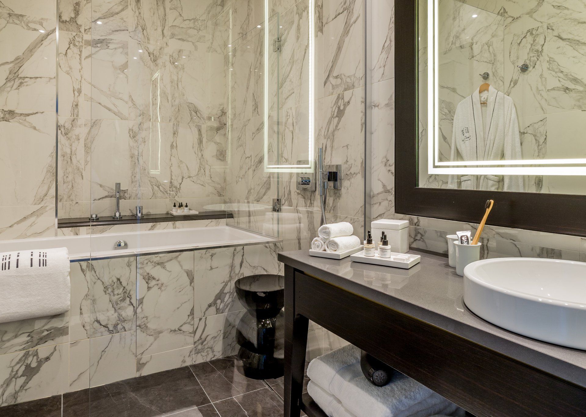 Une salle de bain avec baignoire, lavabo, miroir et serviettes.