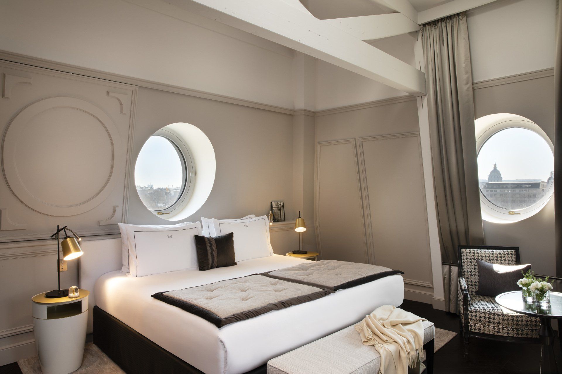 Une chambre avec un grand lit et deux fenêtres rondes