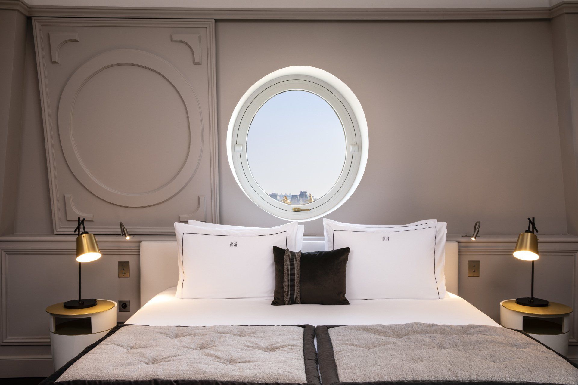 Une chambre avec un lit et une fenêtre ronde