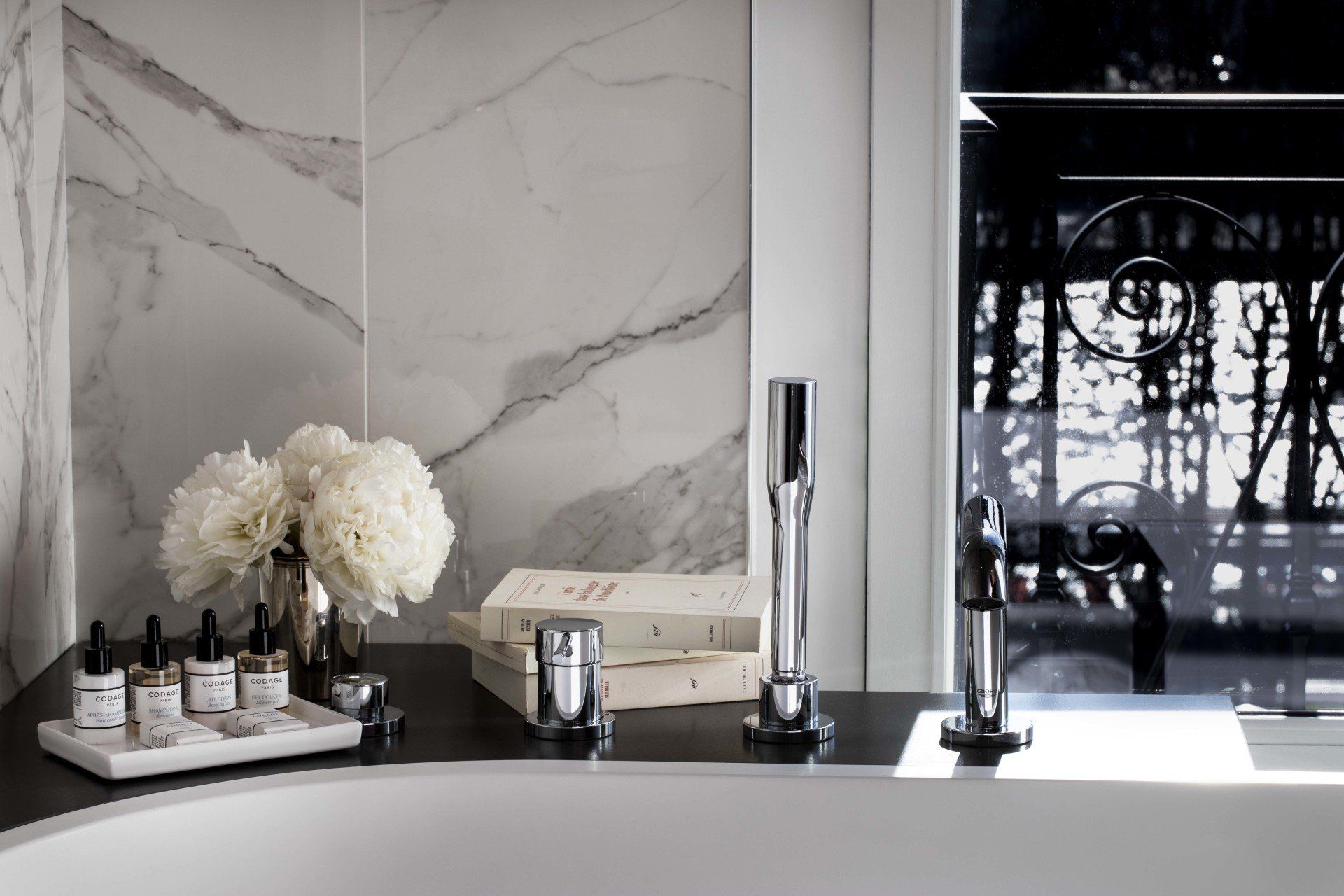 Une salle de bain avec une baignoire et un plateau de bouteilles sur le comptoir