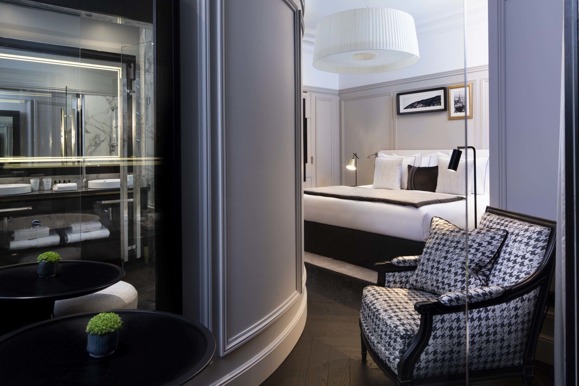 Une chambre d'hôtel avec un lit, une chaise, une table et un miroir.