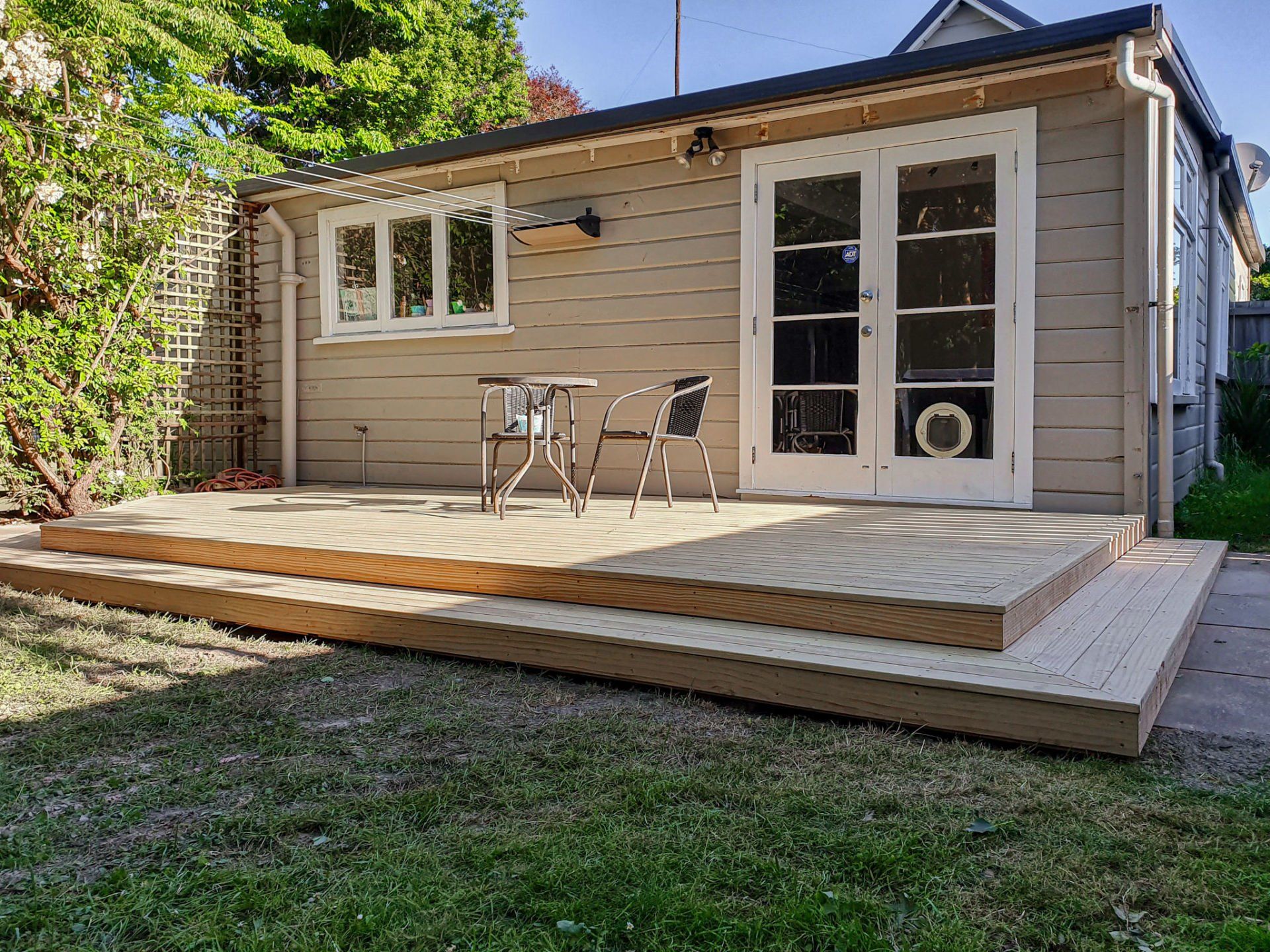 A small house with a deck and chairs in front of it.