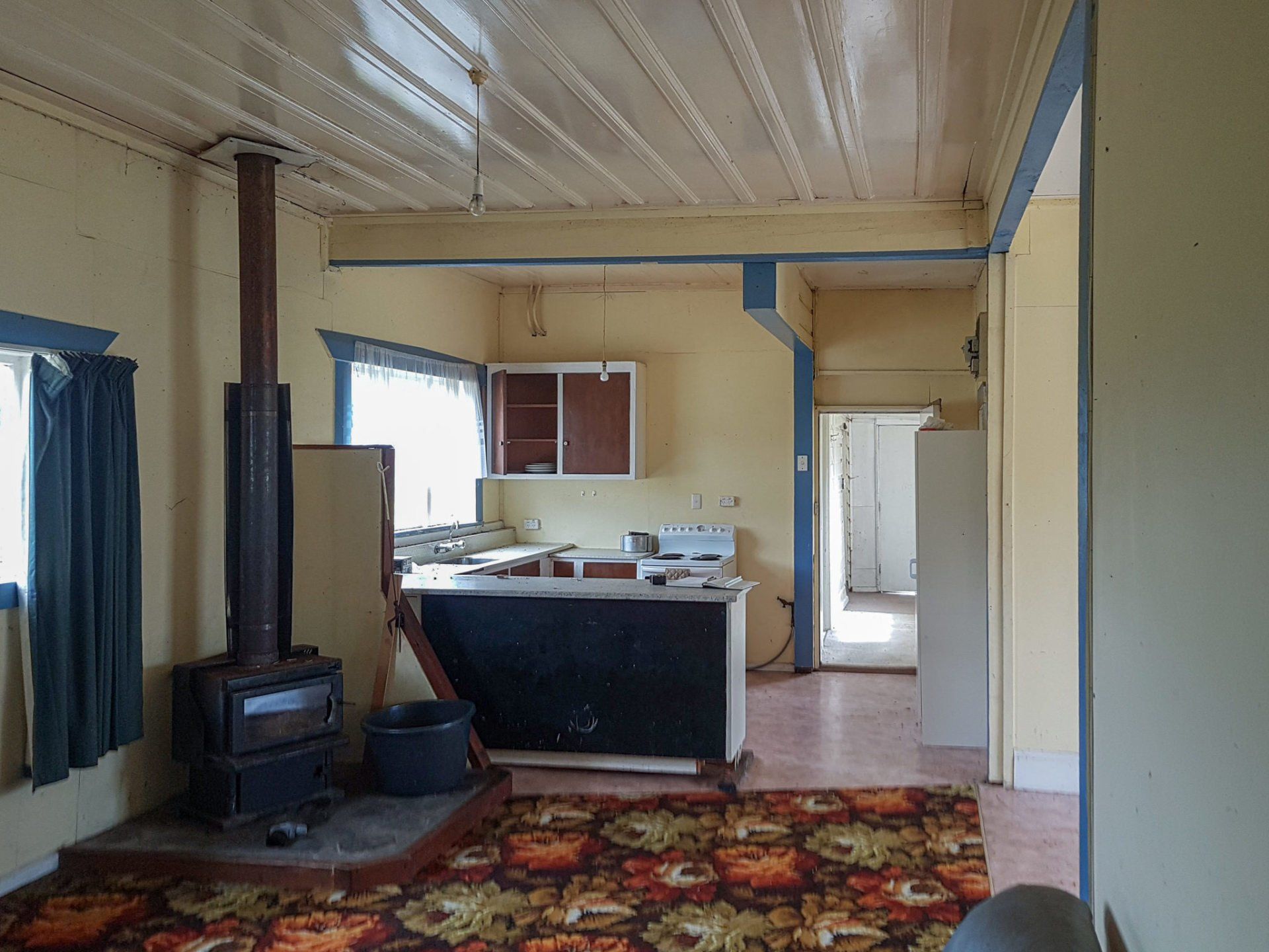 An empty room with a stove and a rug