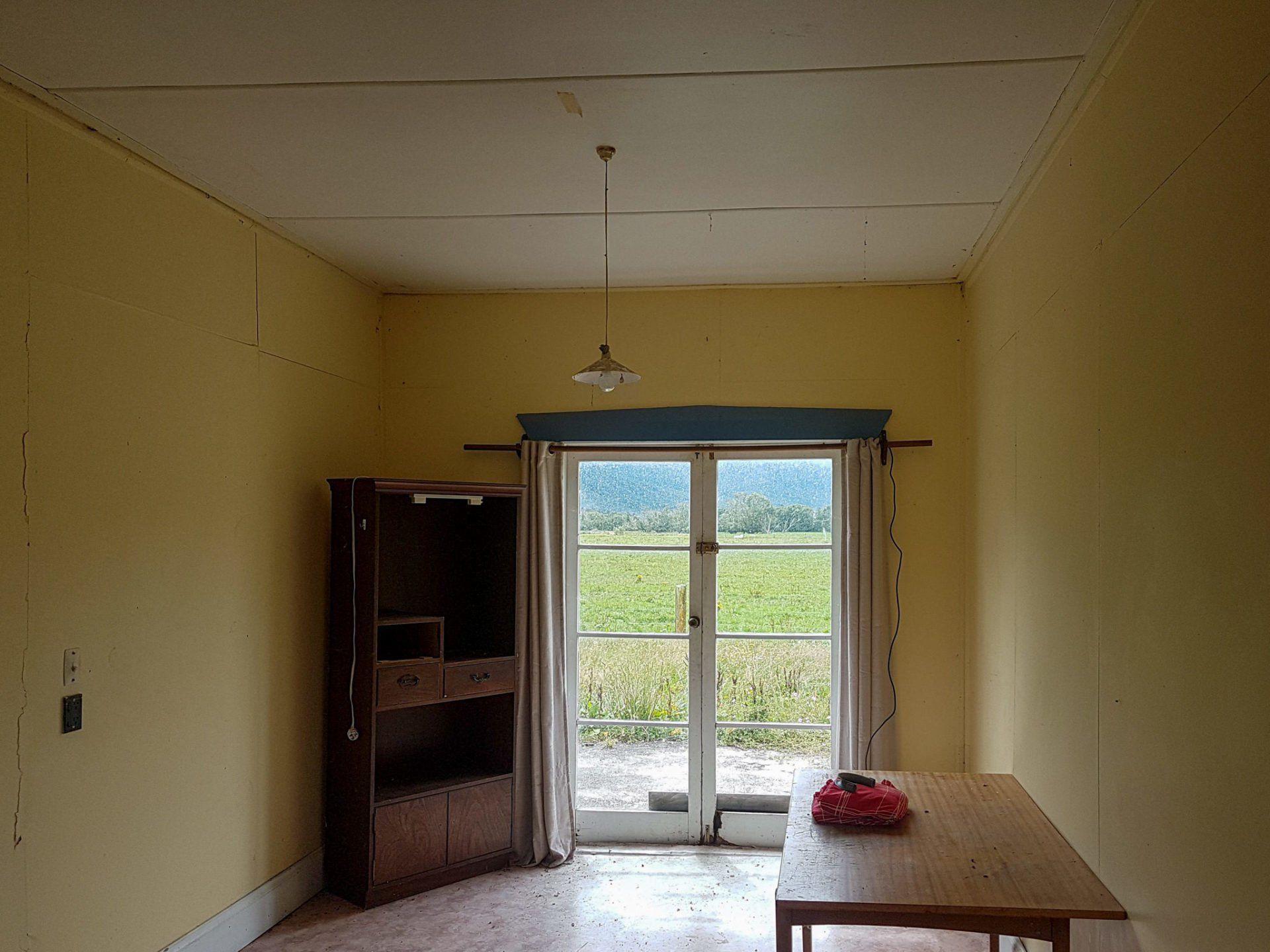 A room with yellow walls and a sliding glass door