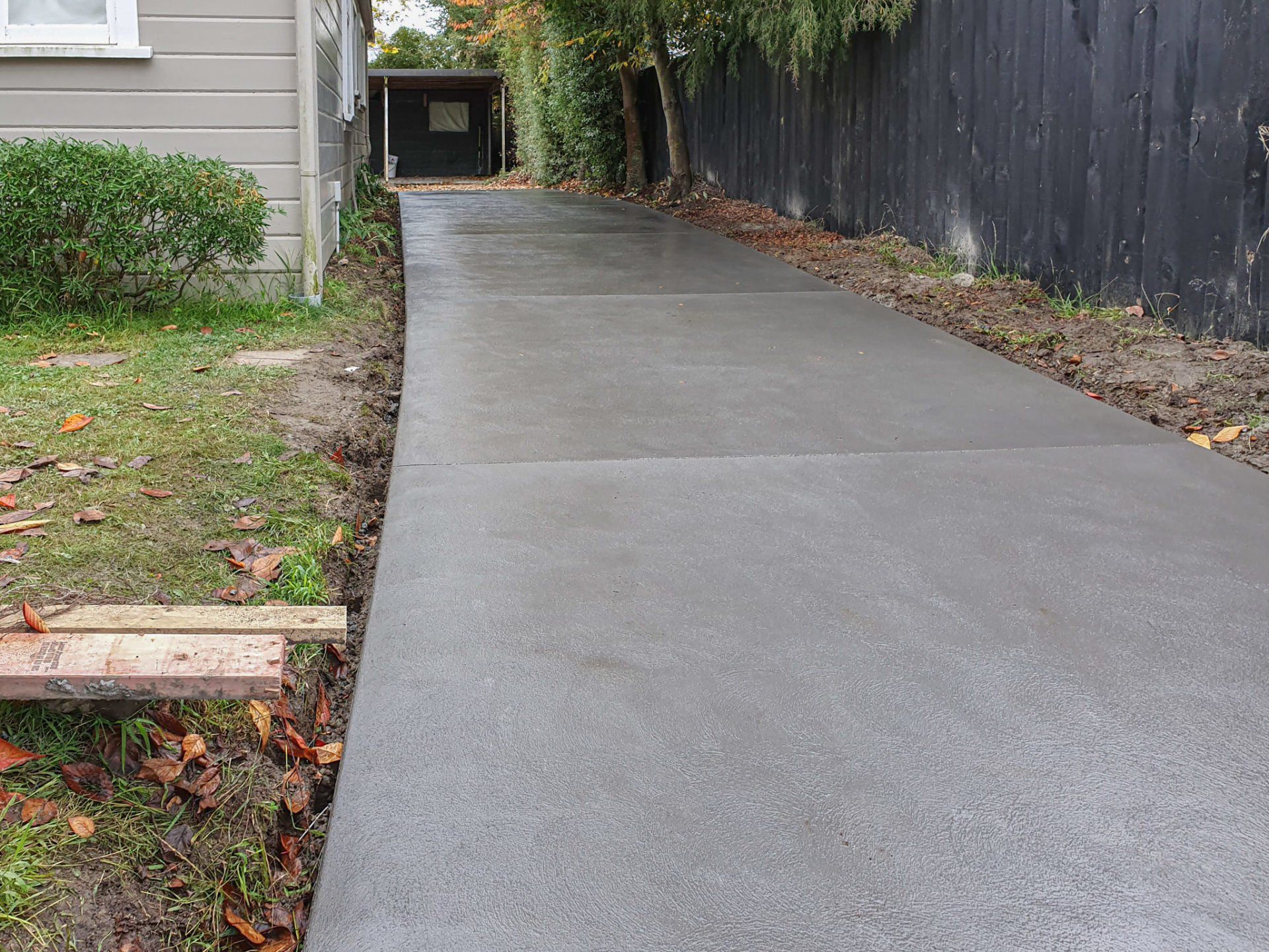 A concrete driveway is being built in front of a house.