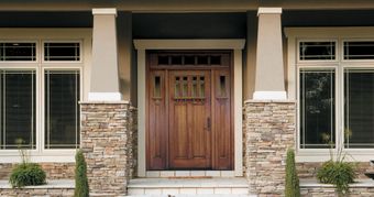 A house with a wooden door and a stone wall
