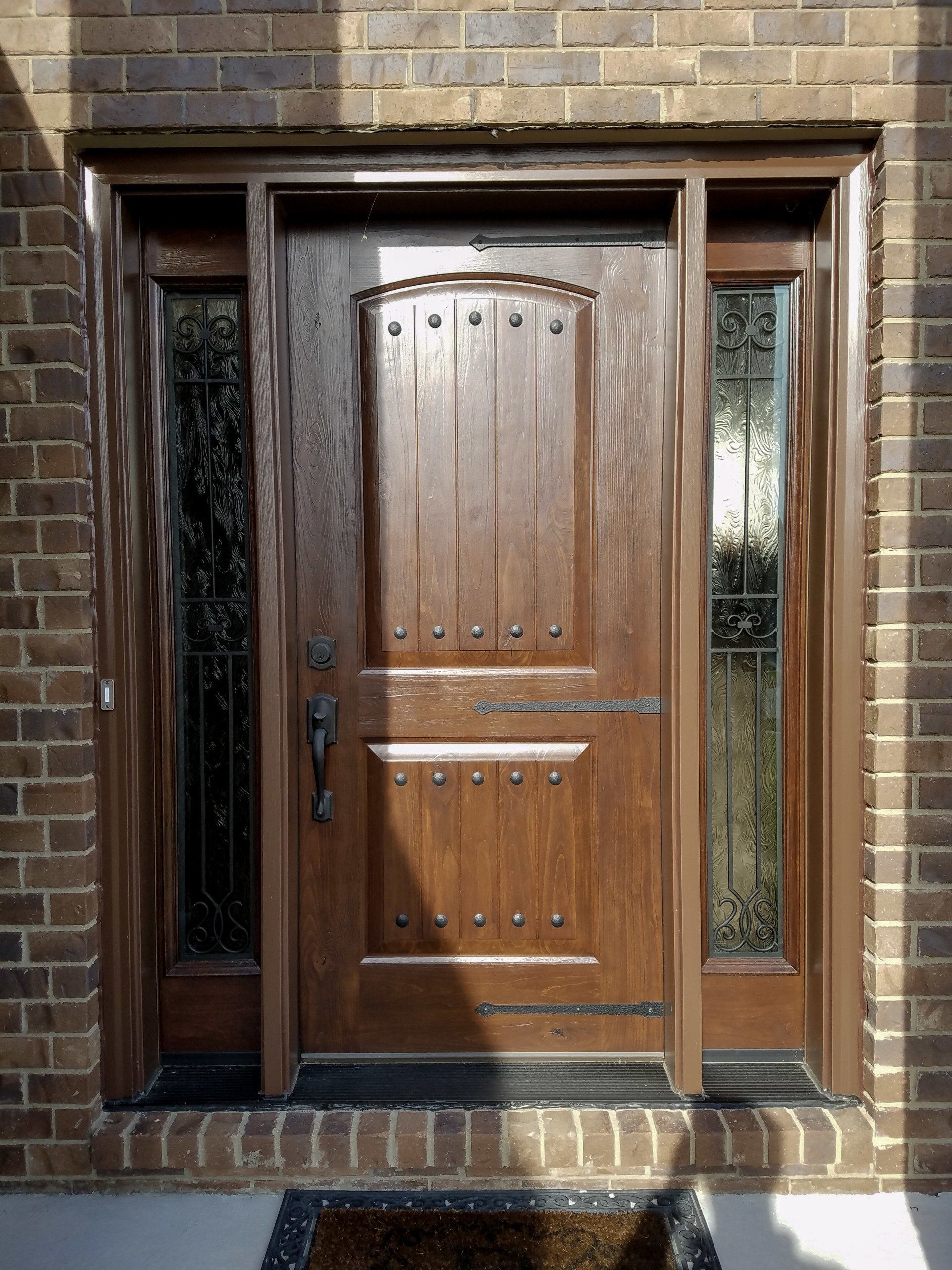 A wooden door with a brick wall behind it