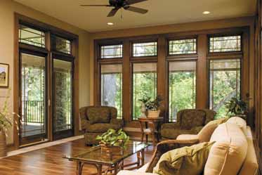 A living room with a lot of windows and a ceiling fan.