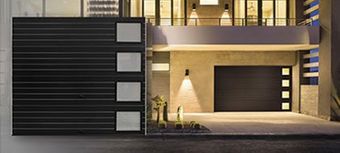 A modern house with a black garage door and a black fence.